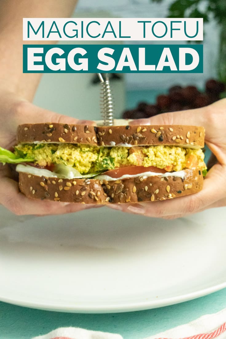 hands holding a tofu egg salad sandwich with lettuce and tomato, text overlay