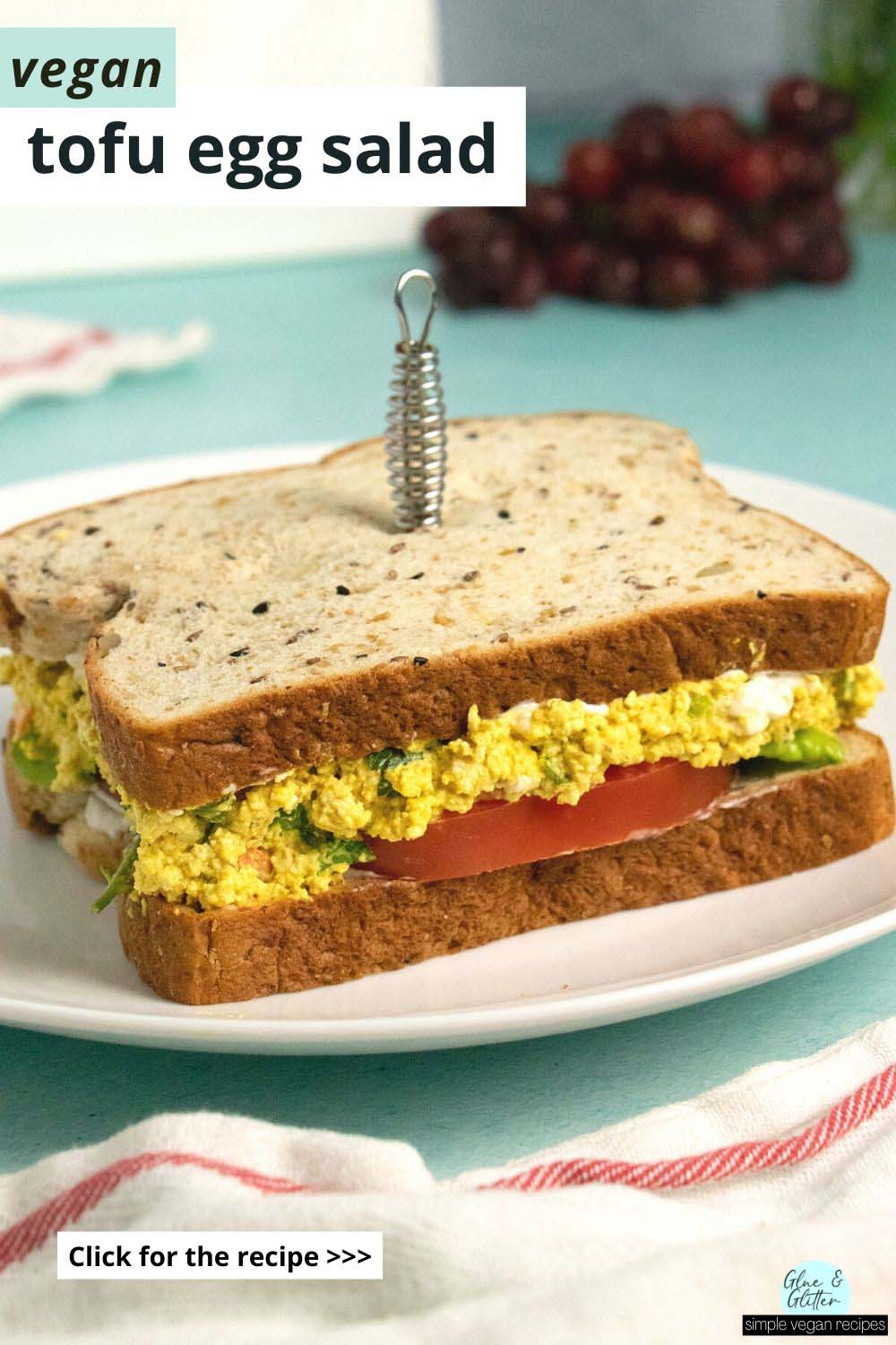 tofu egg salad sandwich on a white plate, text overlay