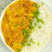 bowl of vegan butter chicken with rice and green onions