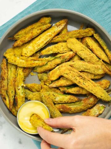 dipping air fryer okra into the sauce