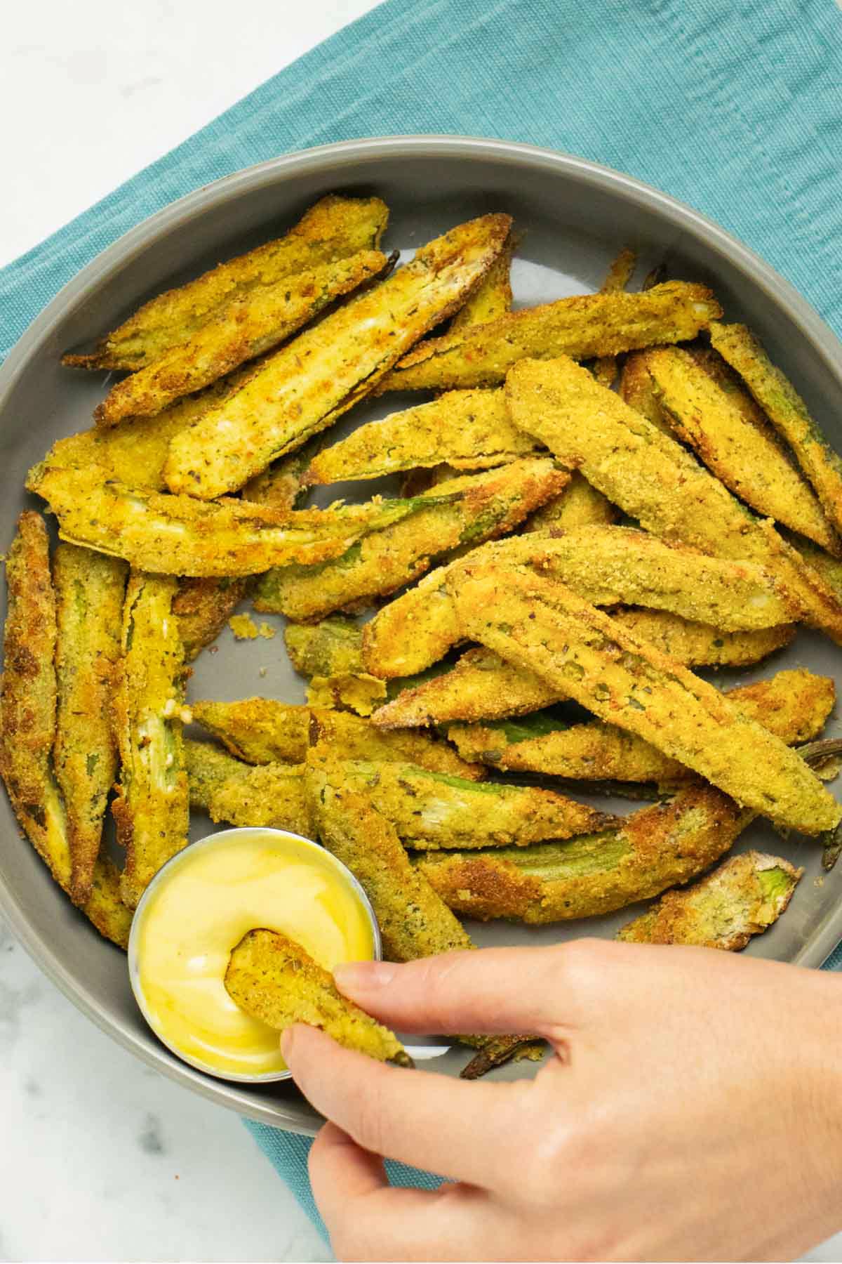 dipping air fryer okra into the sauce