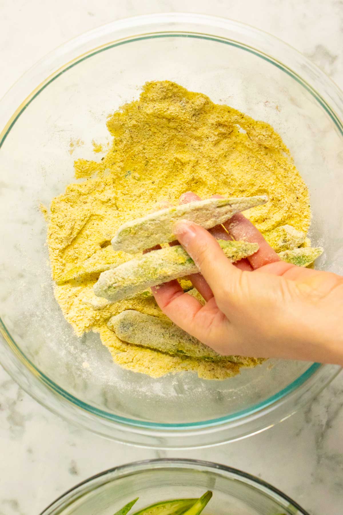 hand holding a breaded piece of okra