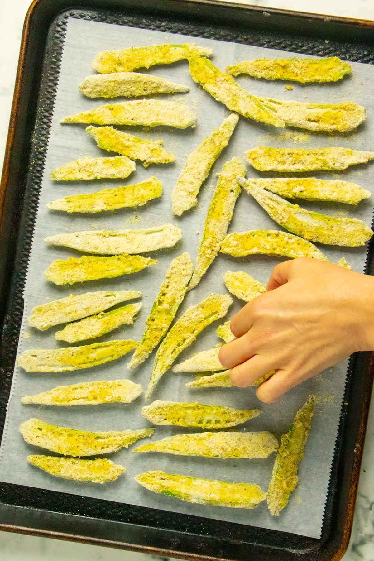 arranging the okra on a baking sheet for the freezer