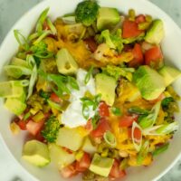 bowl of vegan potato casserole, fully loaded with toppings