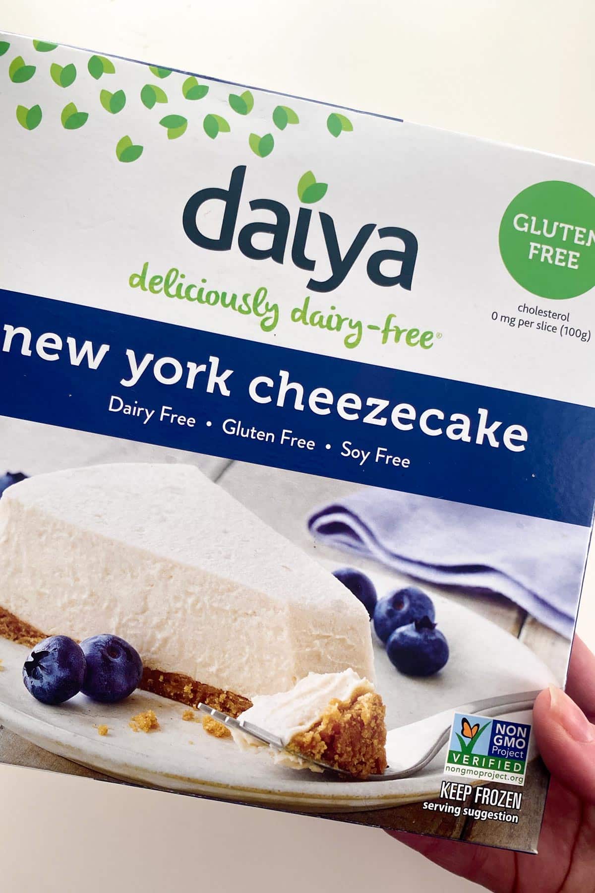 hand holding a box of Daiya New York Cheezecake
