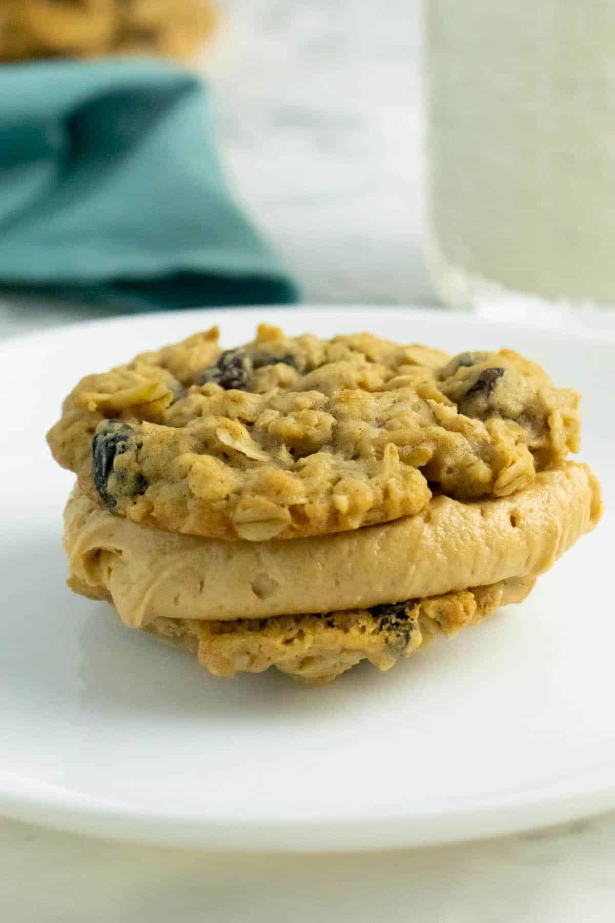 vegan cookie sandwich with oatmeal raisin cookies and peanut butter frosting