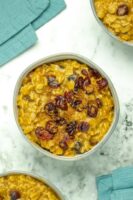 bowls of pumpkin oatmeal with cranberries and pumpkin spice