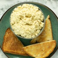 bowl of tofu ricotta on a plate with toast points