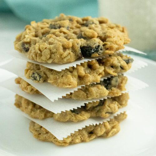 stack of vegan oatmeal raisin cookies on a white plate