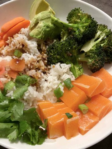 a rice bowl with vegetables, soy sauce, and Vegan Zeastar salmon