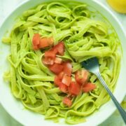 bowl of fettuccine with avocado pesto and tomatoes