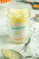 DIY sugar hand scrub in a jar with an orange and teal label