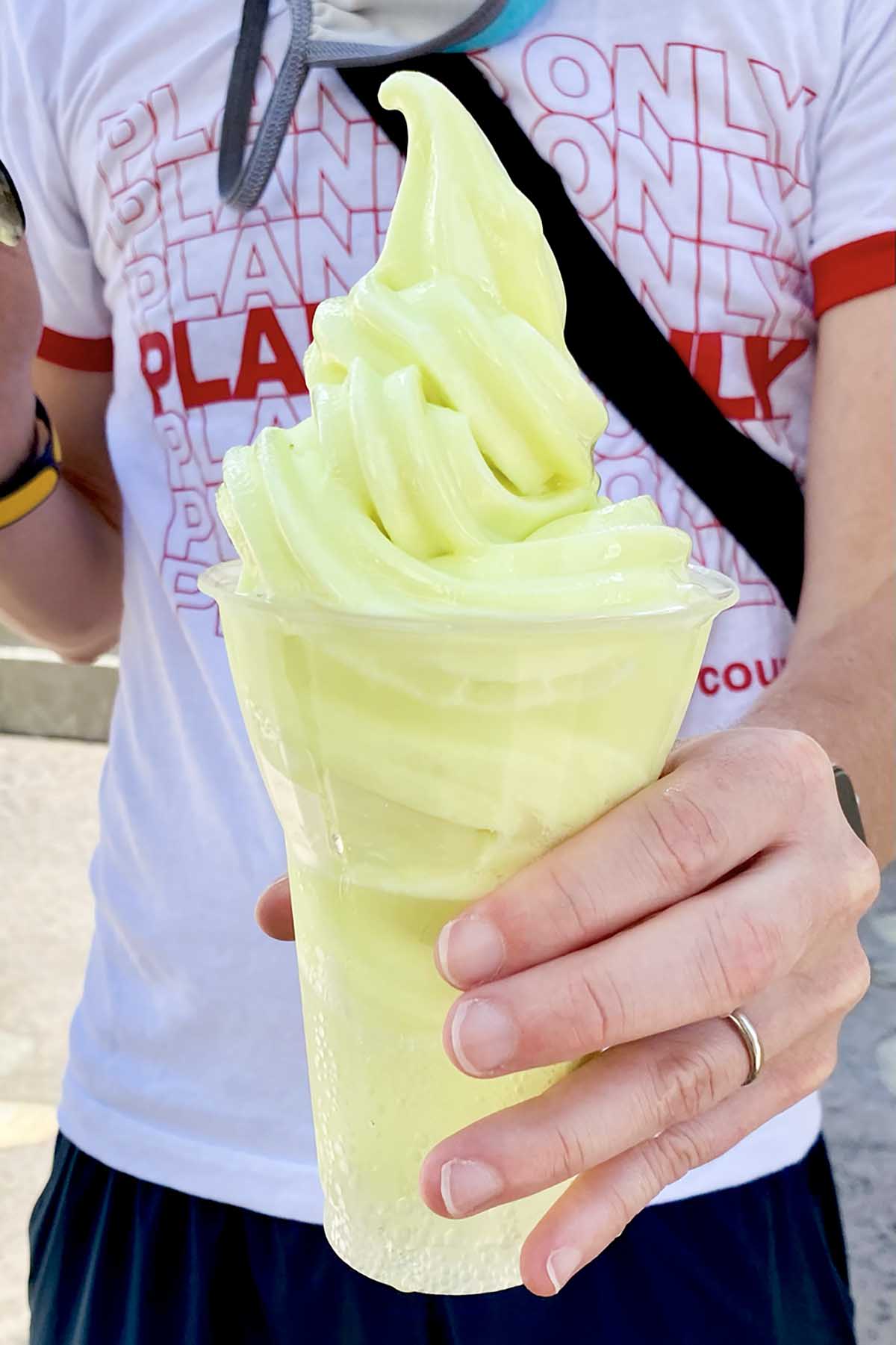person in a shirt that says, "Plants Only" holding a green ice cream float