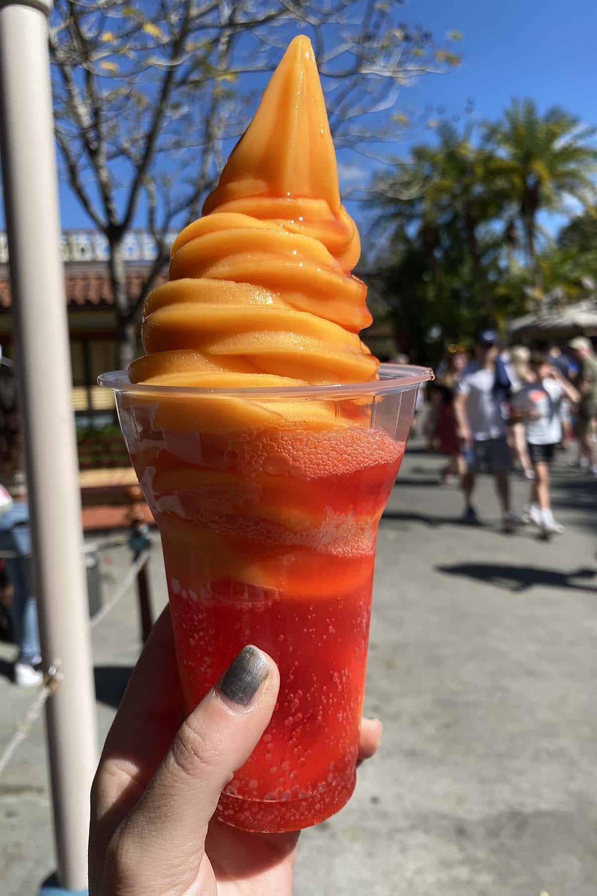 hand holding an I Lava You Float: red soda with orange soft serve and red syrup