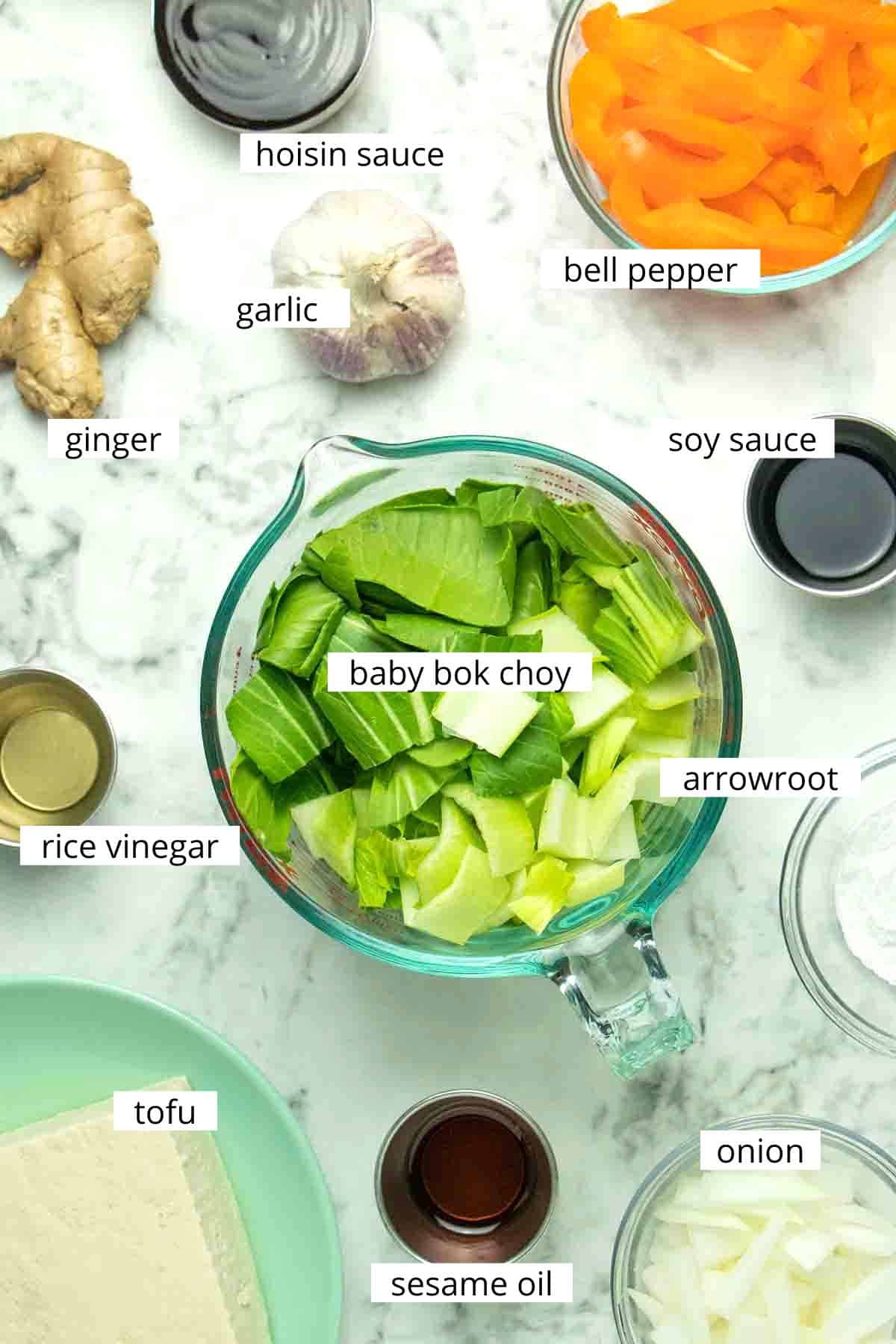 air fryer stir fry ingredients in bowls on a marble table with text labels on each one