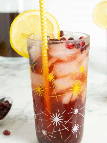glasses of pomegranate lemonade on a table with a pitcher