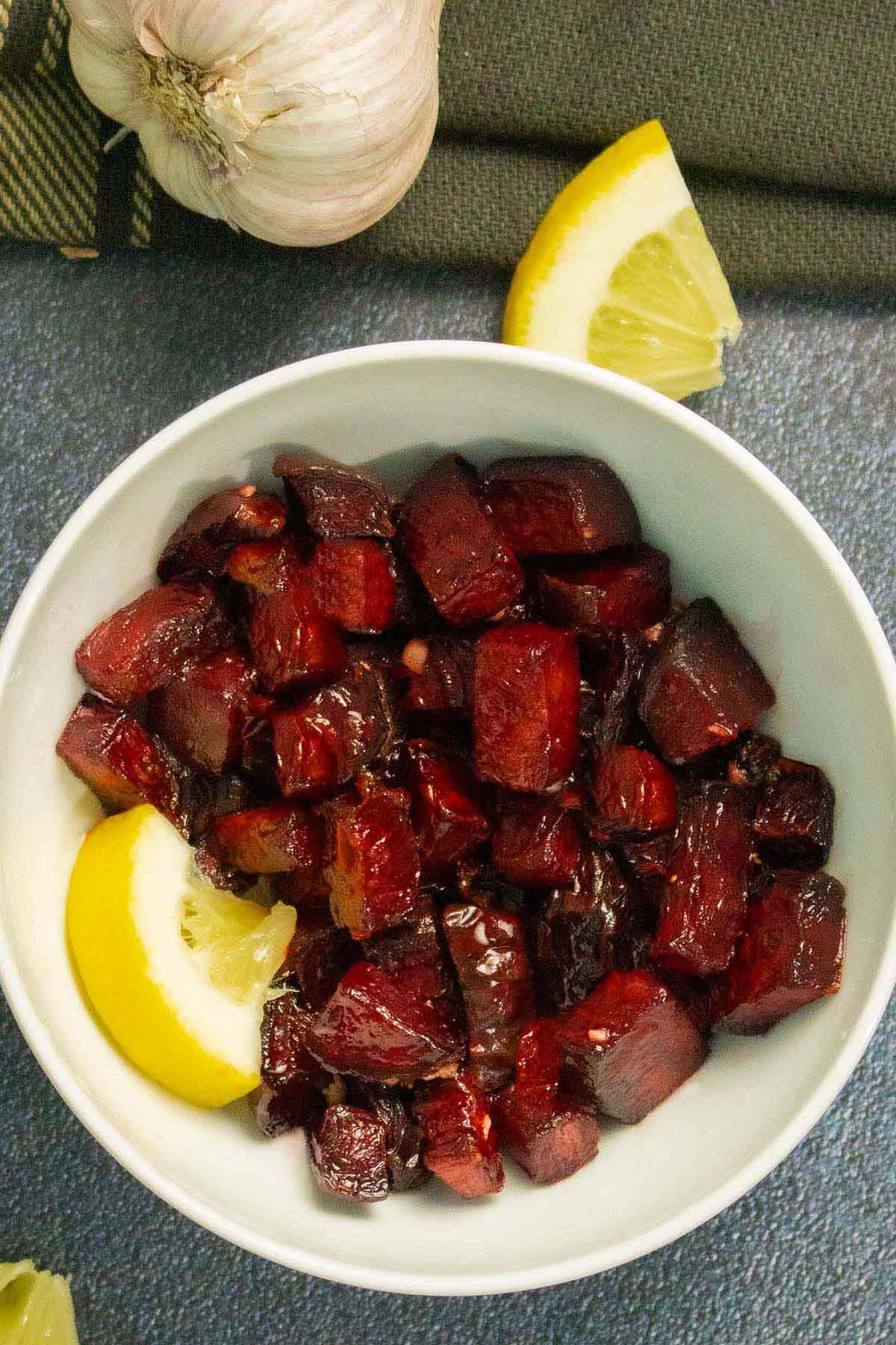 air fryer beets with a lemon wedge in a white bowl