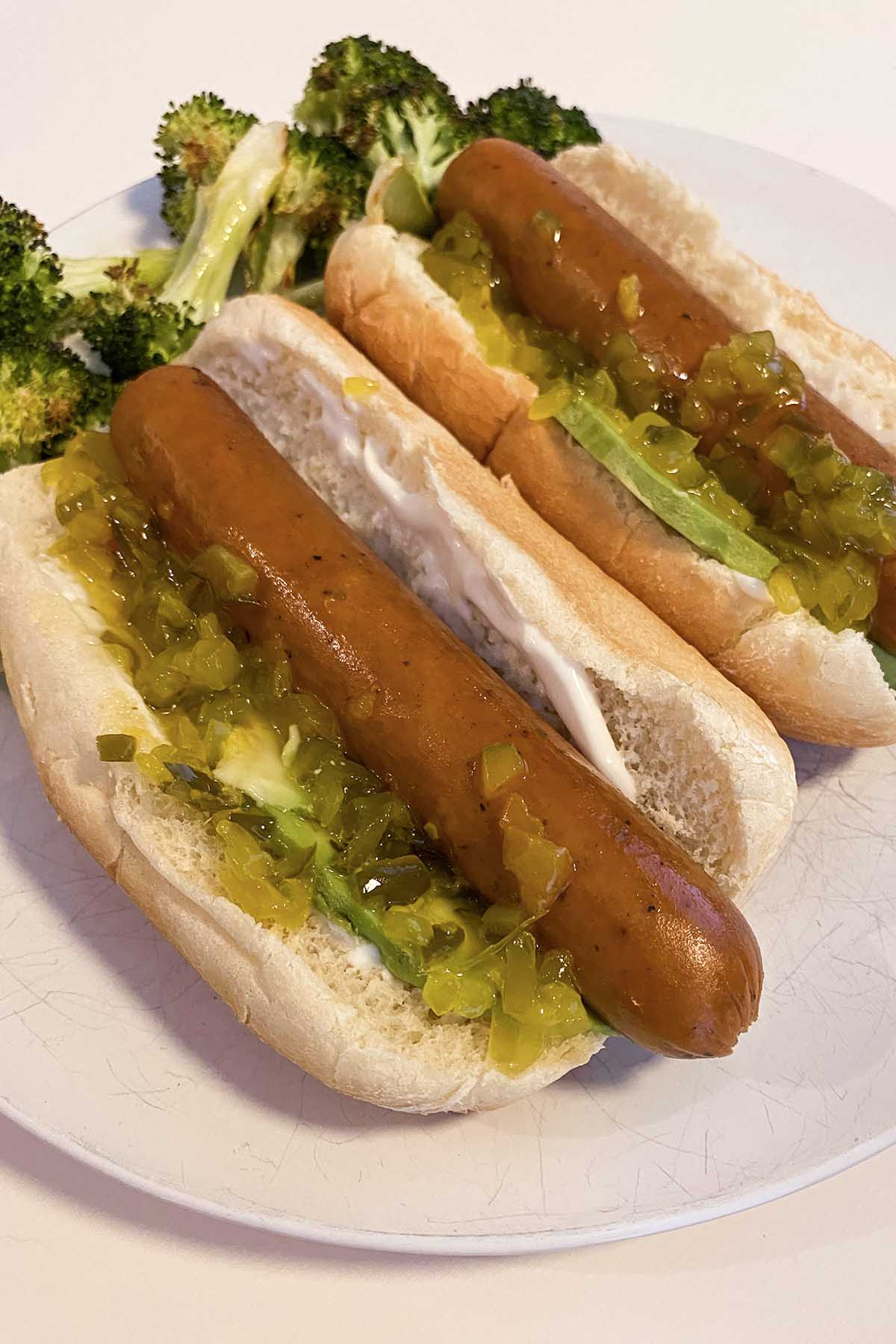 Field Roast Frankfurters on a bun with avocado, relish, and mayo with a side of roasted broccoli