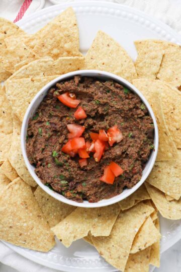 black bean dip in a bowl surrounded by tortilla chips