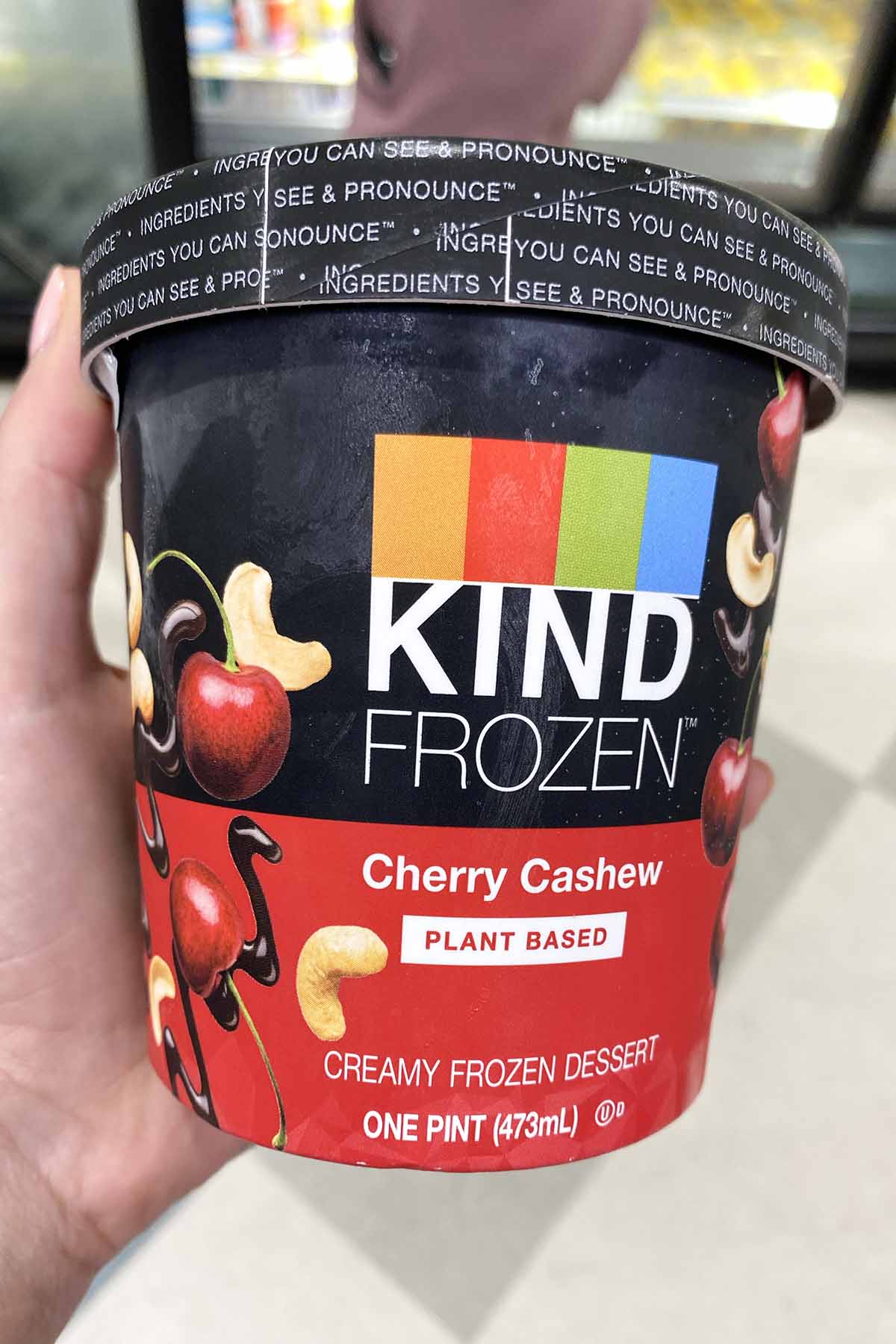 hand holding a pint of KIND Frozen Cherry Cashew