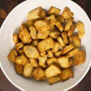 air fryer croutons in a white bowl on a wood table