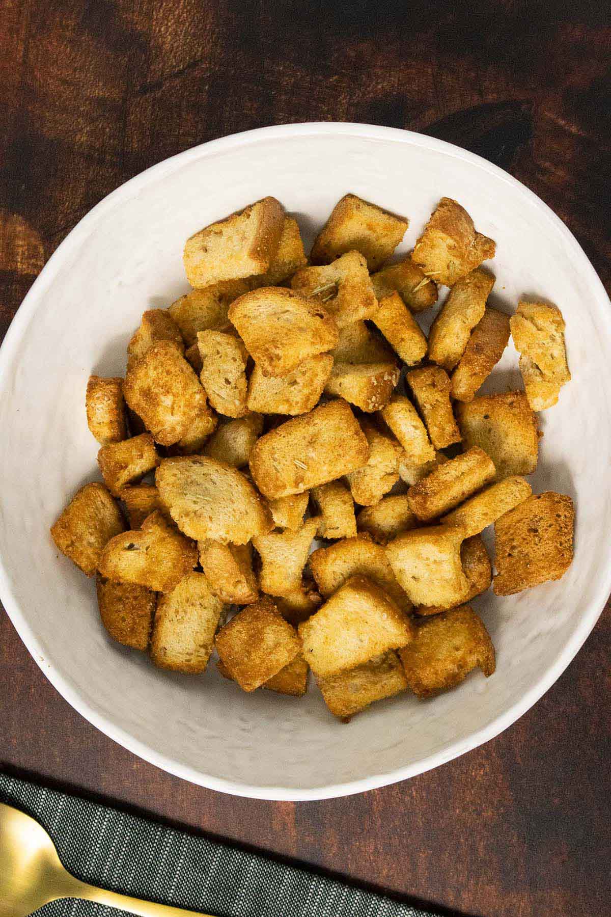 air fryer croutons in a white bowl on a wood table