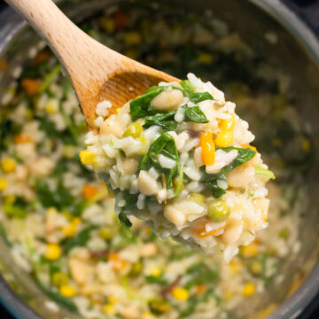 wooden spoon full of vegan risotto over an Instant Pot