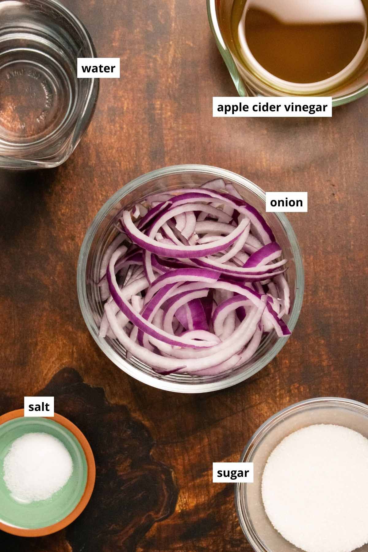 pickled onion ingredients in bowls on a wooden table