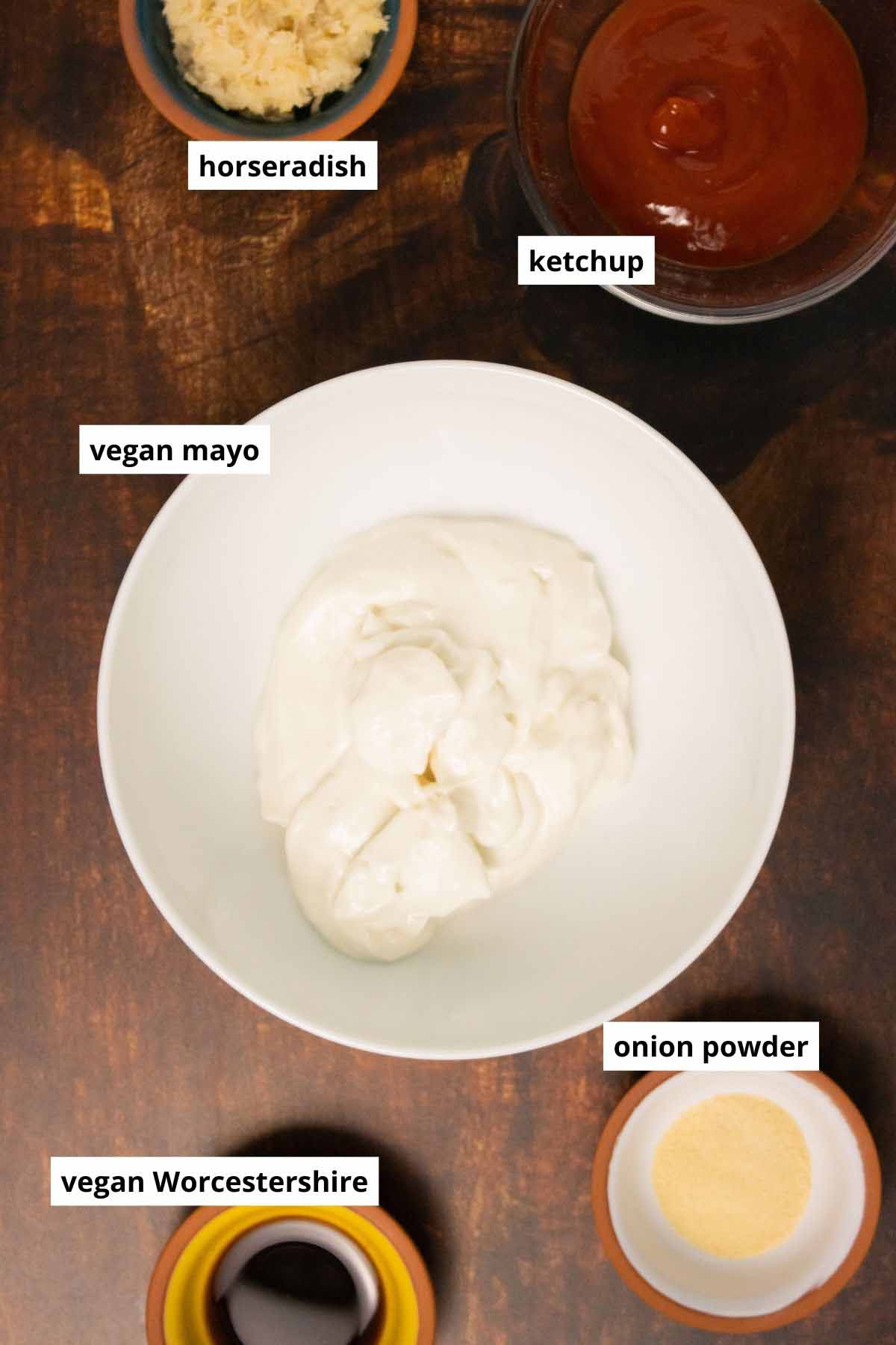 vegan mayo, ketchup, and seasonings in bowls on a wooden table