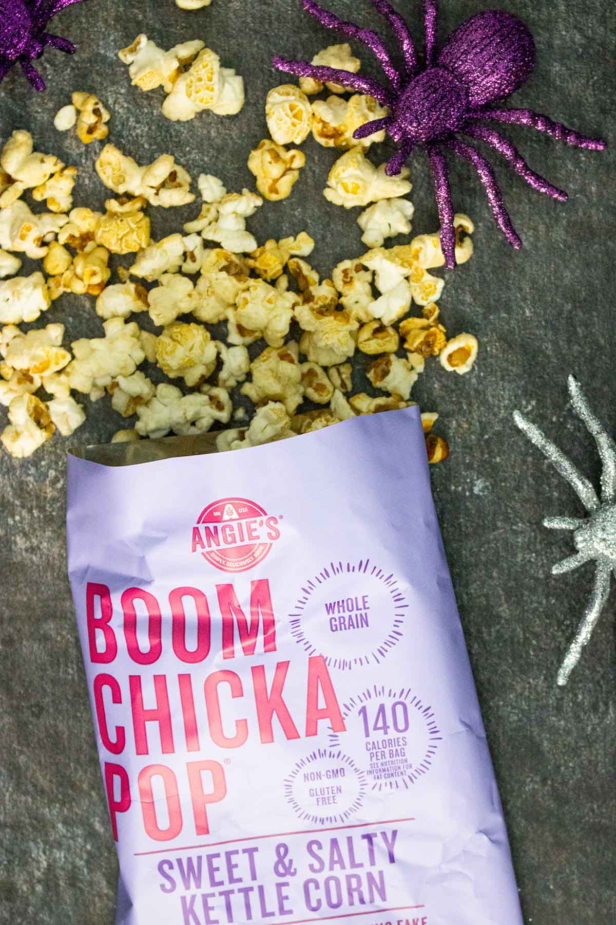 open back of Boom Chicka Pop kettle corn on a slate table with glitter spiders