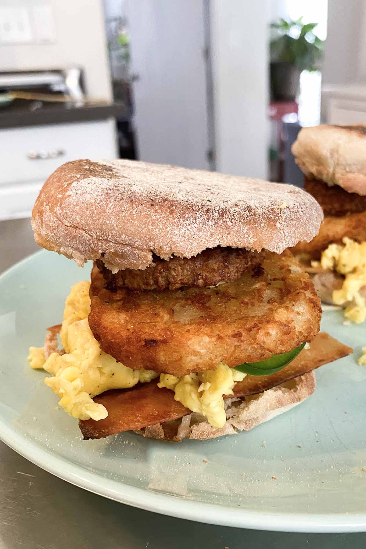 English muffin sandwich with hash brown, vegan egg, jalapeño, and vegan meats