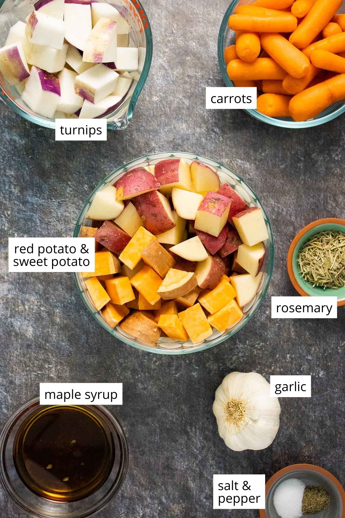 root vegetables, maple syrup, salt, and spices in bowls on a slate table