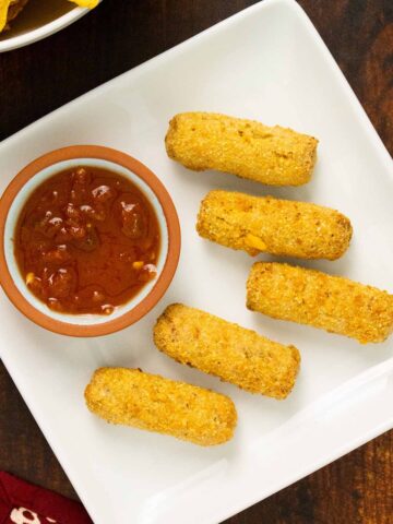 MorningStar Farms Veggie Chick'n & Cheeze Taquito Bites on a plate with salsa to dip