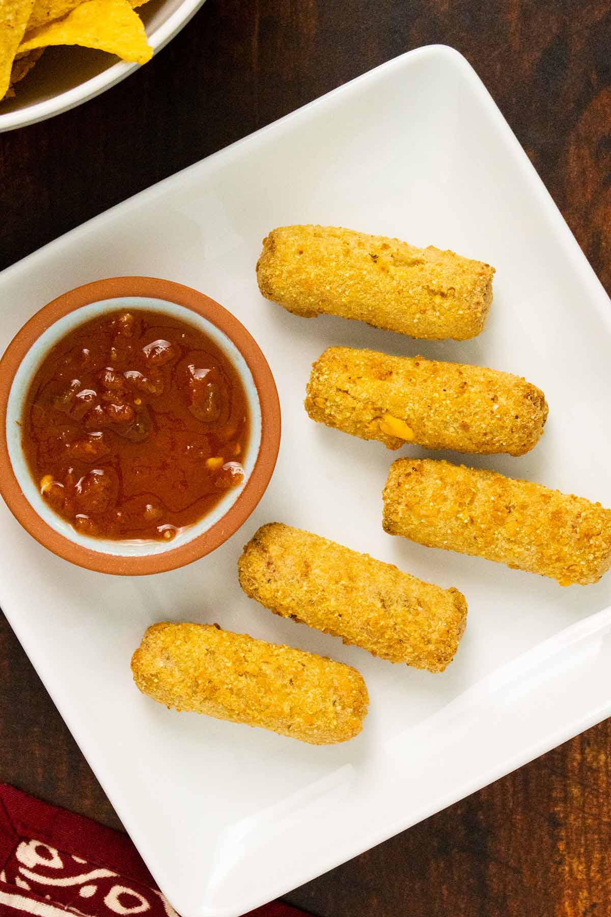 MorningStar Farms Veggie Chick'n & Cheeze Taquito Bites on a plate with salsa to dip