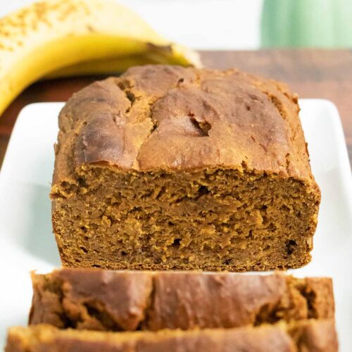close-up of sliced vegan pumpkin banana bread on a white plate, so you can see the texture