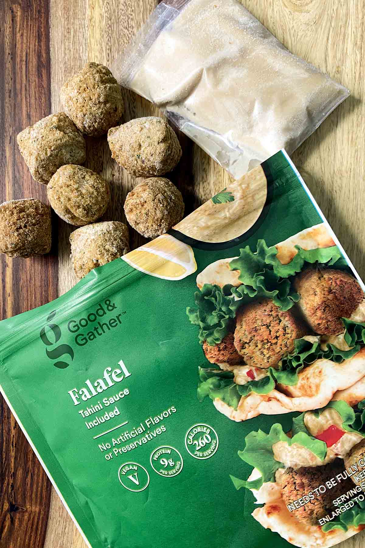 frozen Good & Gather Falafel on a wooden butcher block table next to the sauce packet