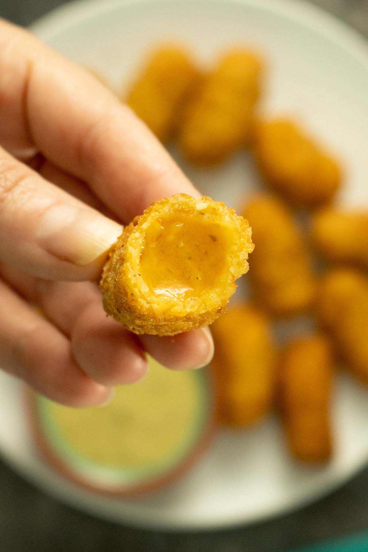 close-up of a Wholly Veggie Cheddar Jalapeno Stick with a bite out, so you can see the cheesy filling