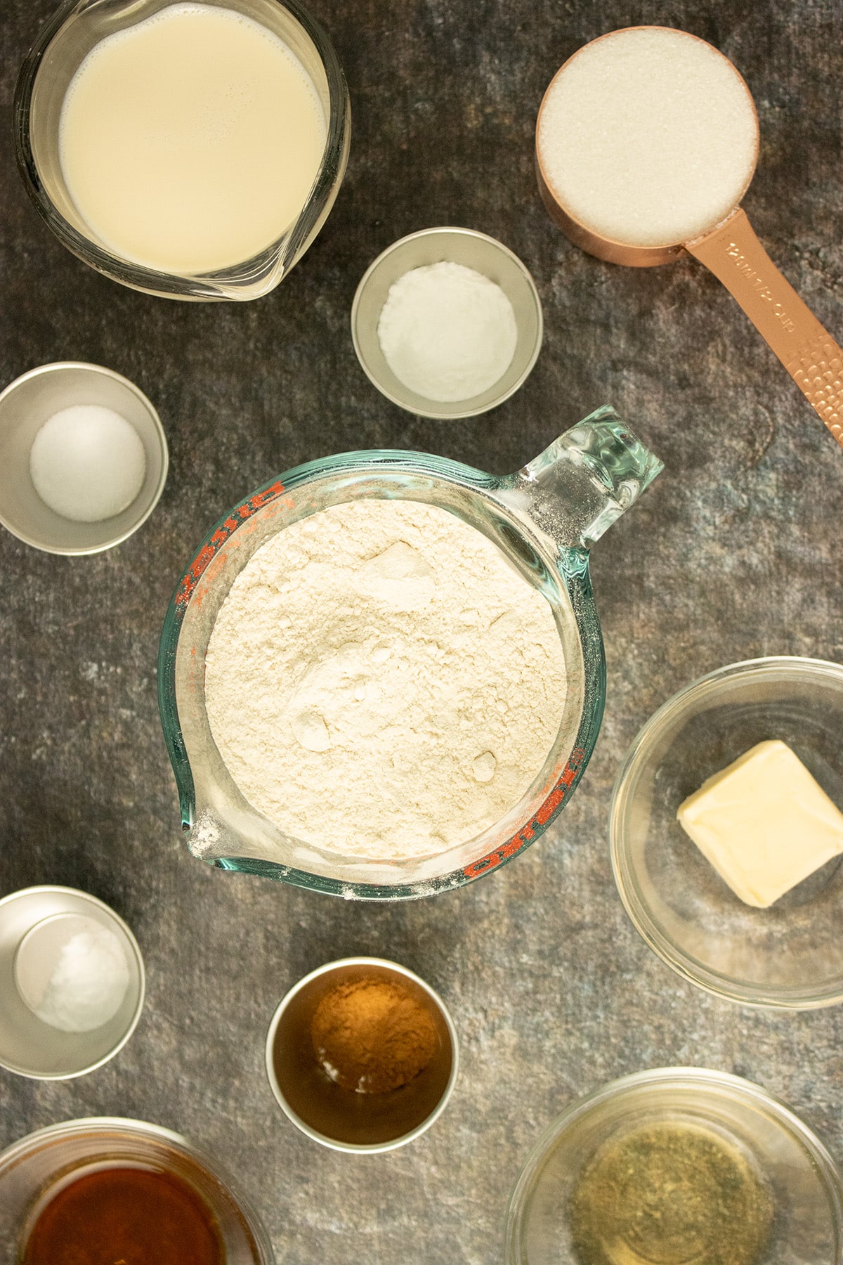 white wheat flour in a measuring cup surrounded by other scones ingredients