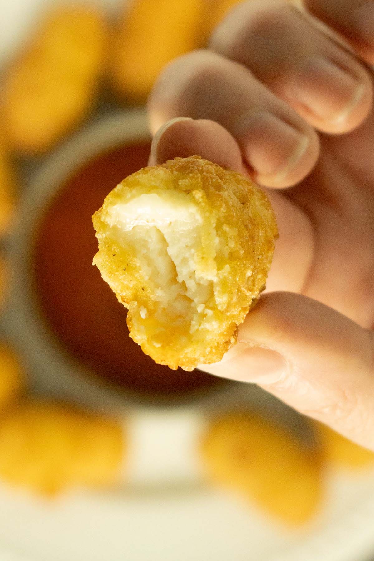close-up of a vegan mozzarella stick with a bite out of it