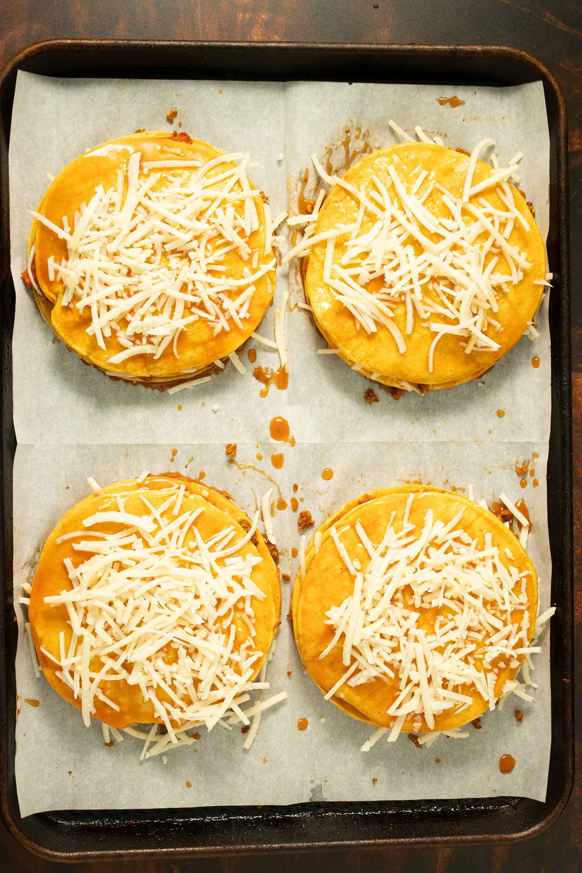 sprinkle of vegan cheese on top of the stacked enchiladas