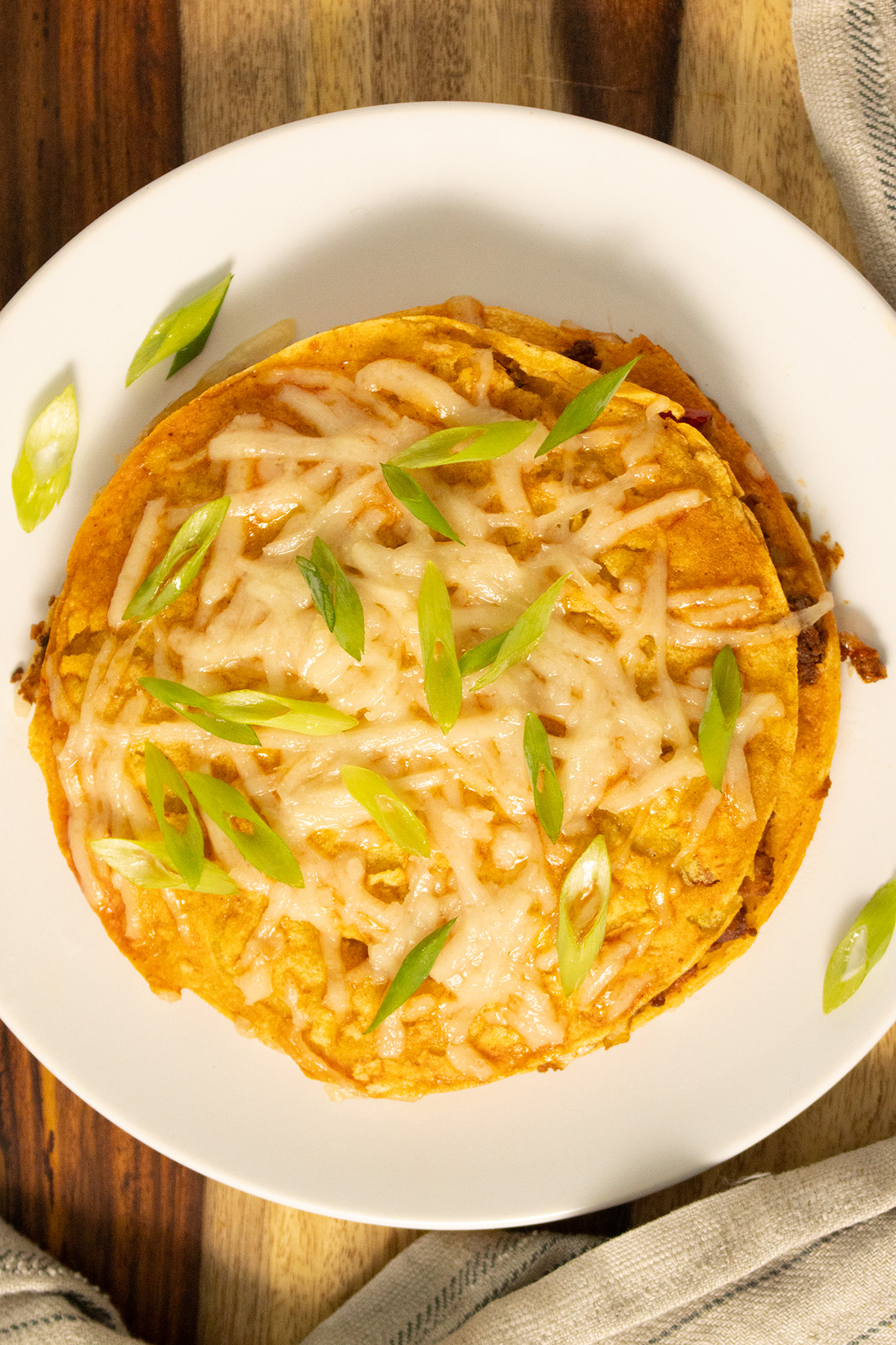 overhead shot of stacked enchiladas on a plate