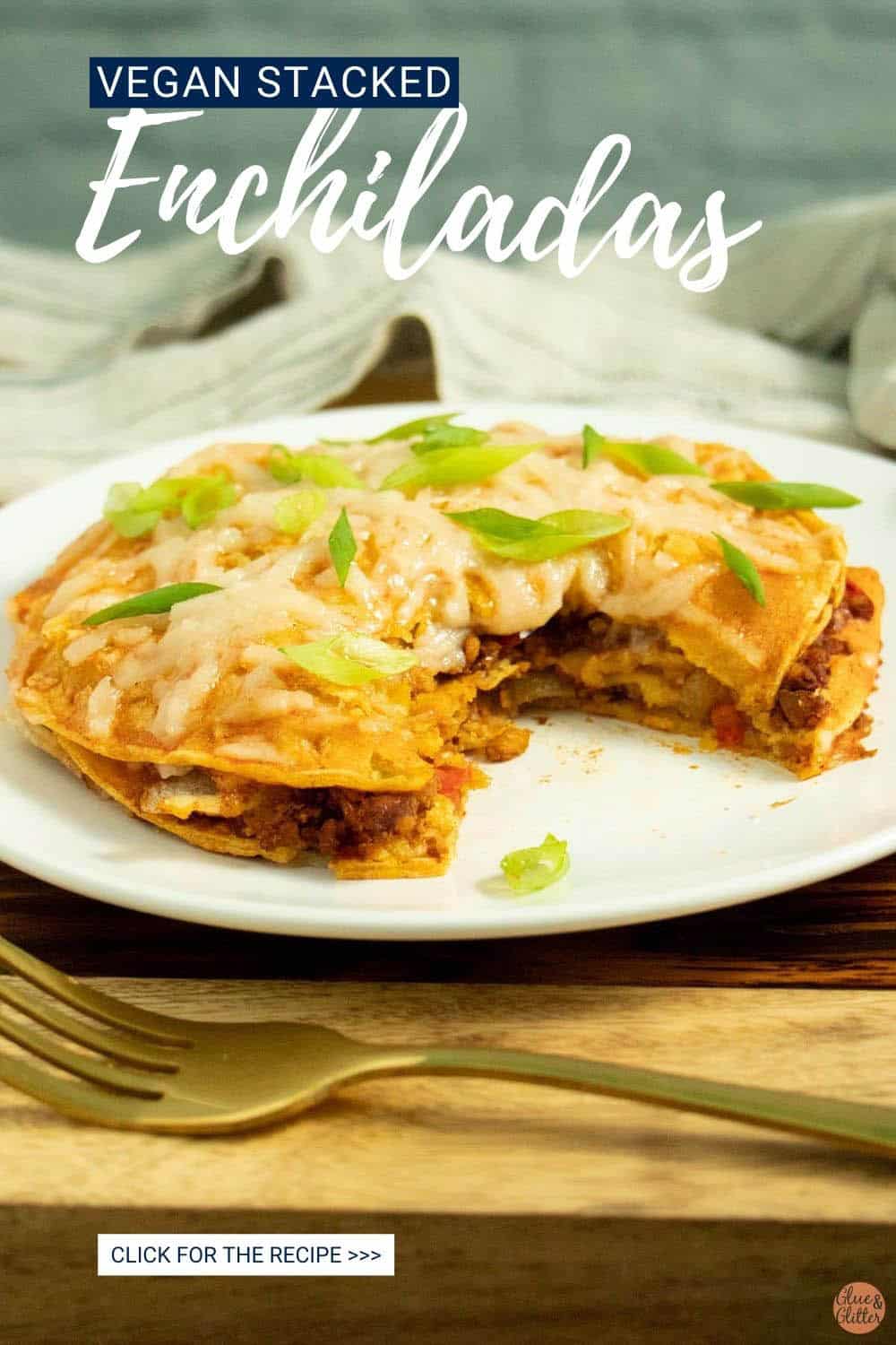 vegan stacked enchiladas on a white plate with a bite taken out, so you can see the layers inside, text overlay