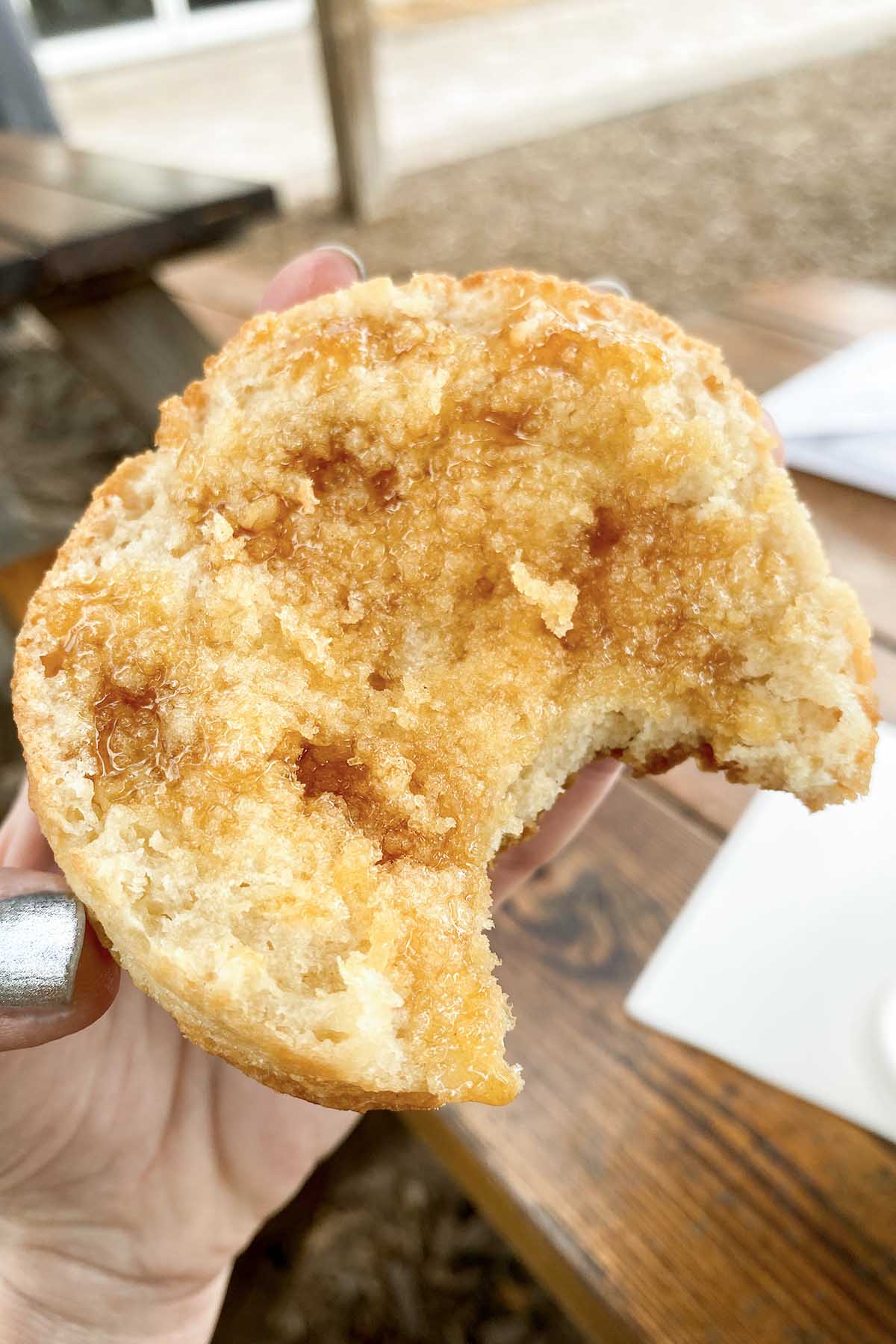 hand holding a vegan biscuit with honey