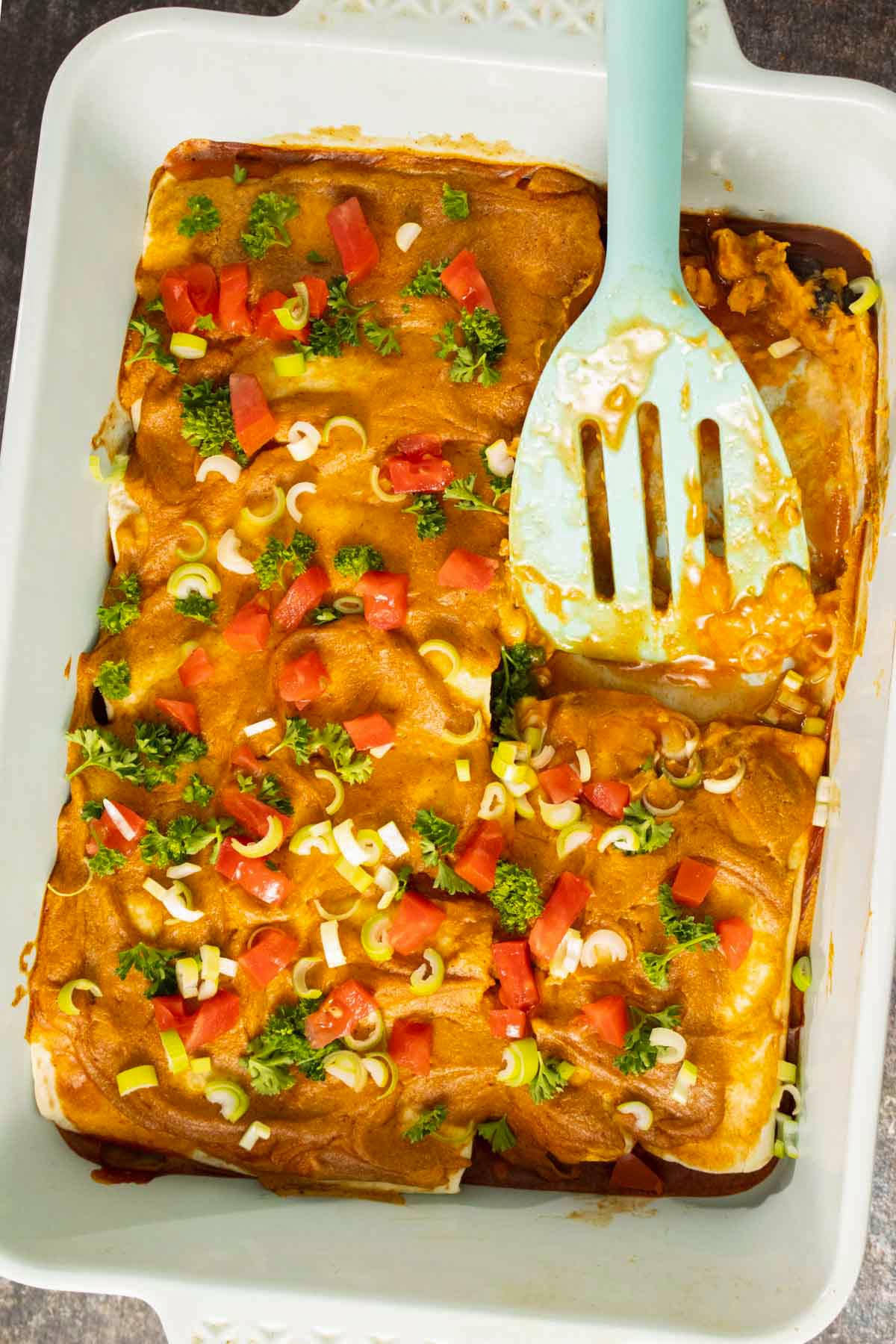 serving black bean sweet potato enchiladas from the pan