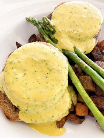 Cafe Sunflower tofu Benedict with asparagus and potatoes in a white, shallow bowl