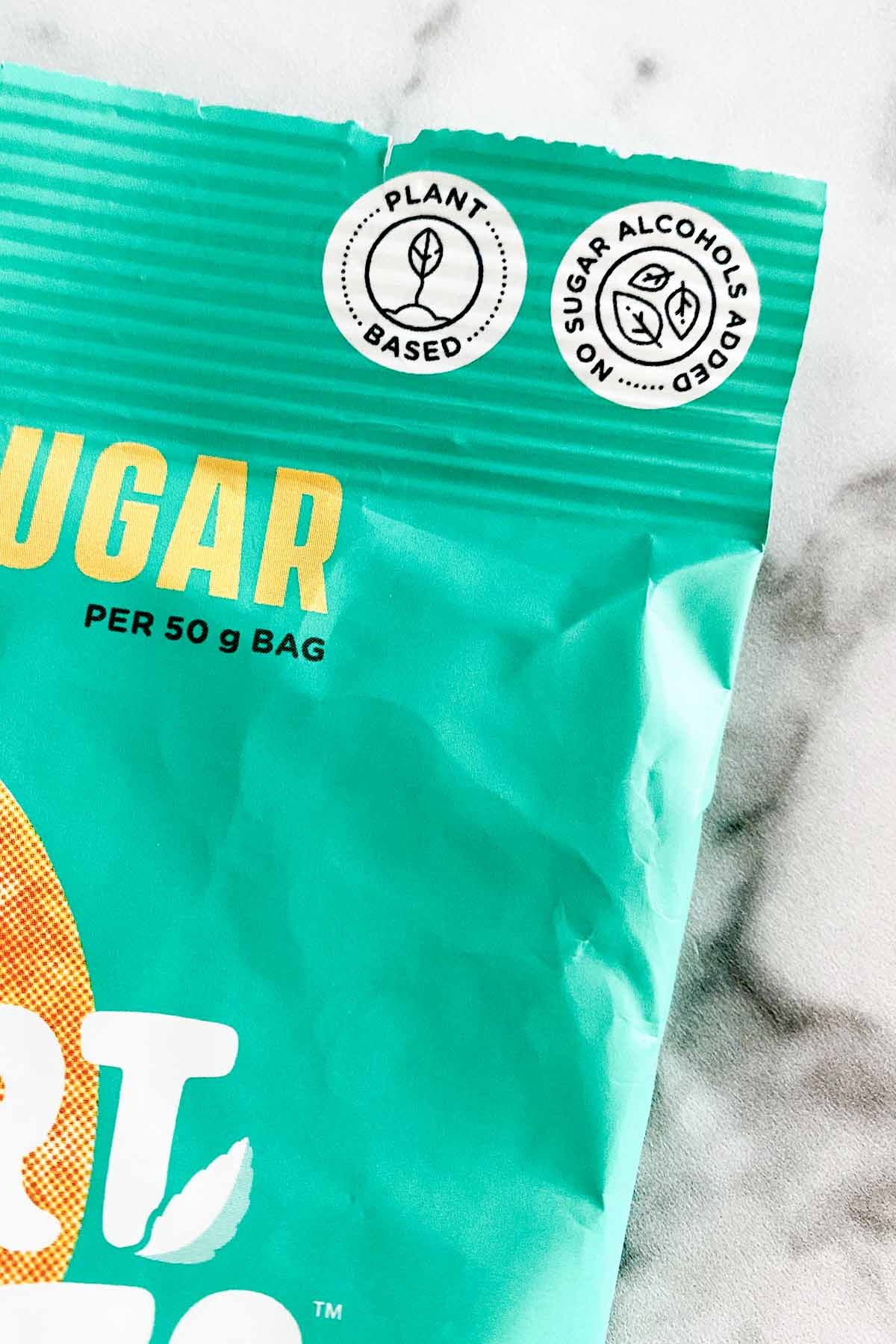 close-up of a package of Smart Sweets vegan gummies package, showing the white circle that says Plant Based inside it.