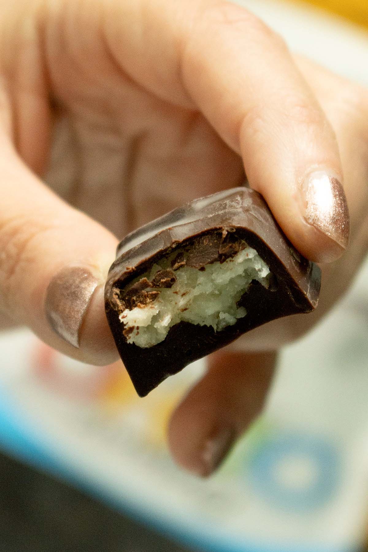 close-up of a piece of Ocho candy with a bite taken out, so you can see the coconut filling