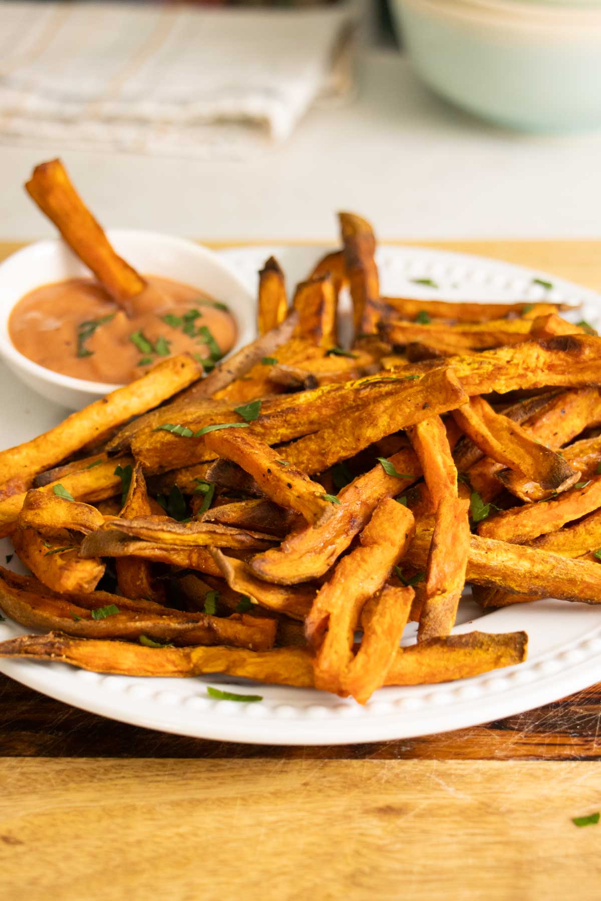 plate of sweet potato oven fries with a ramekin of dipping sauce