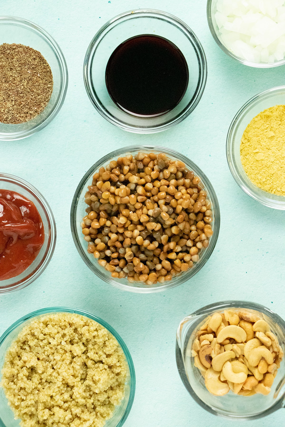 lentils, quinoa, and other ingredients in bowls on a blue table
