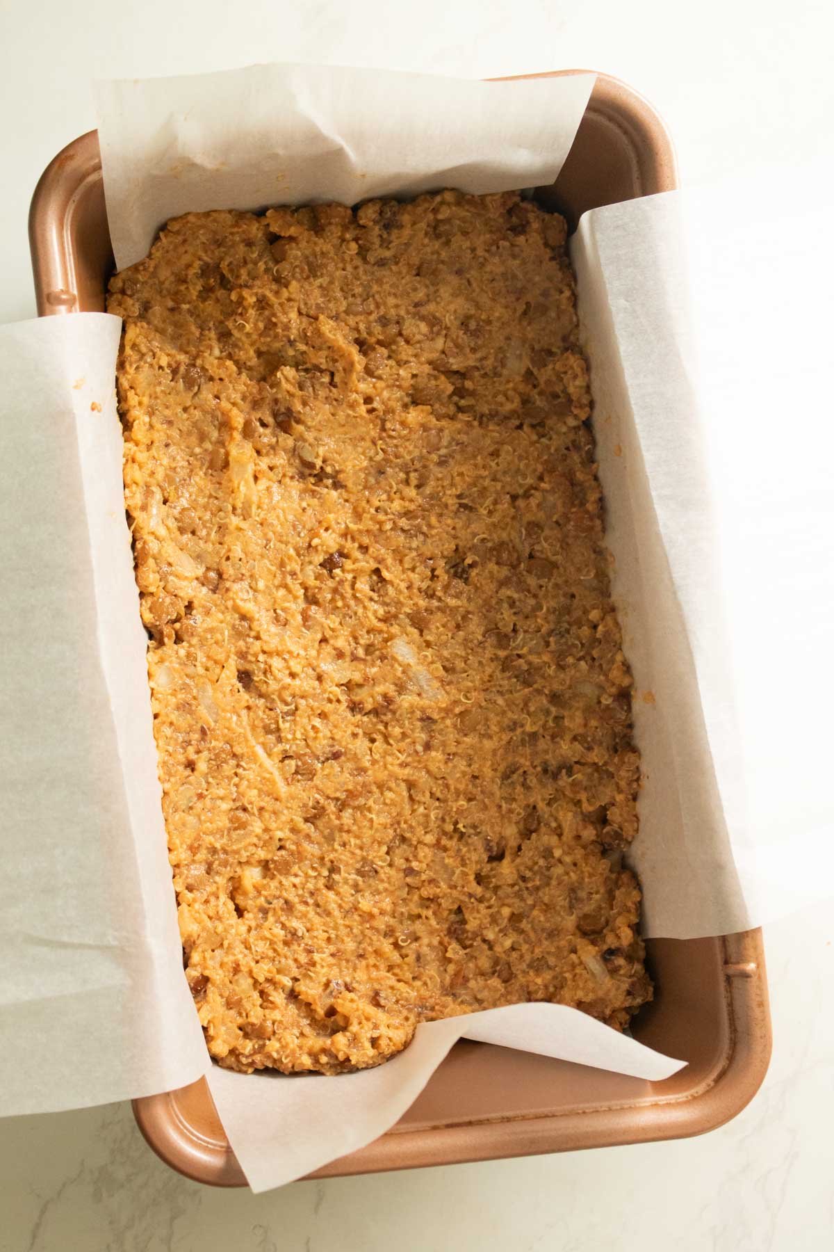 quinoa lentil meatloaf mixture pressed into the pan before glazing